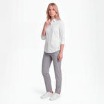 Woman wearing a white shirt and gray pants on a white background
