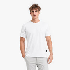 Man wearing a white t-shirt and light gray pants on a white background