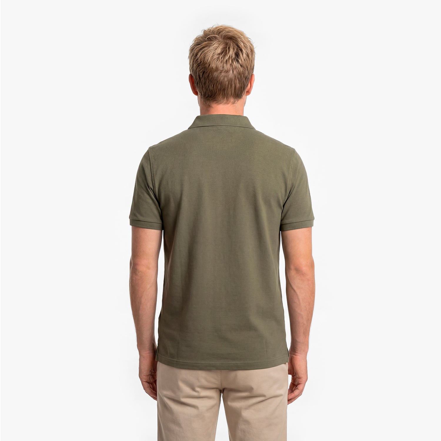 Back view of a man wearing a green polo shirt on a white background