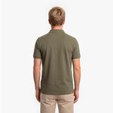 Back view of a man wearing a green polo shirt on a white background