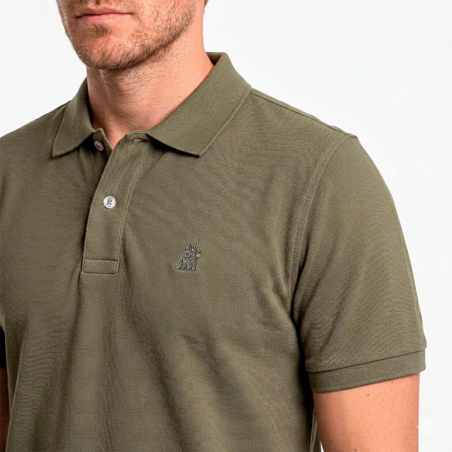 Close-up of a man wearing a green polo shirt with a small logo on a white background