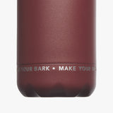 Close-up view of the bottom part of the maroon water bottle, showcasing the text 'MAKE YOUR MARK' printed in white.