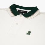 Close-up of the embroidered dog logo on the white polo shirt: A small embroidered dog logo in dark green is visible on the left chest of the shirt.