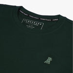 Close-up of the collar and inner label of the dark green t-shirt, showing the brand information and neck design.