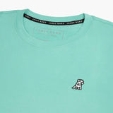 Close-up of the collar and inner label of the mint green t-shirt, showing the brand information and neck design.