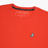 Close-up of the collar and inner label of the orange t-shirt, showing the brand information and neck design.