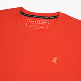 Close-up of the collar and inner label of the orange t-shirt, showing the brand information and neck design