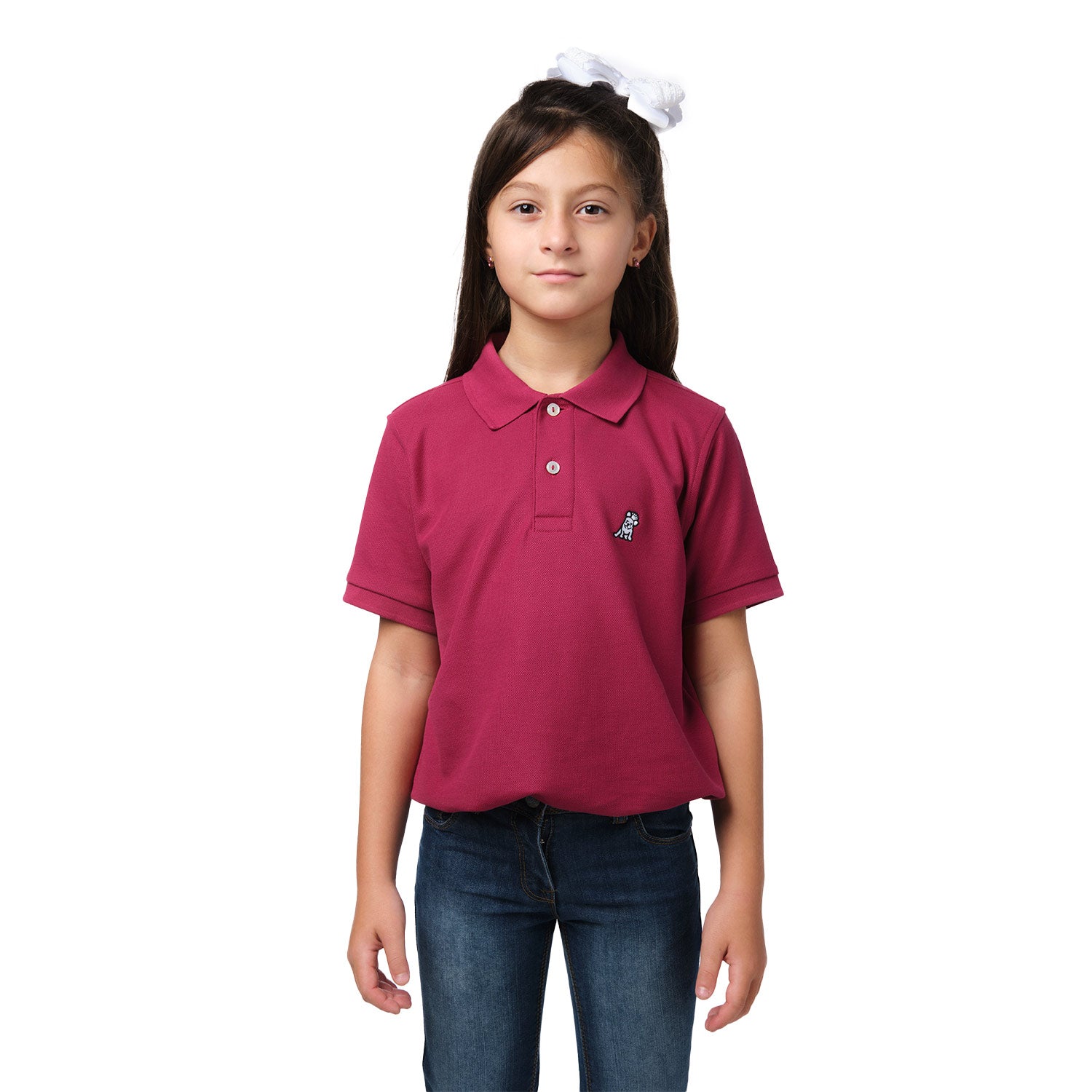 A young girl wearing a burgundy polo shirt with a small embroidered logo on the chest, standing and smiling with her hands at her sides.