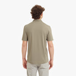 Man wearing a beige polo shirt on a white background