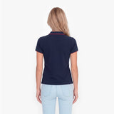 Back view of a woman wearing a navy polo with an embroidered dog logo on a white background