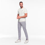 Man wearing a white t-shirt and gray pants on a white background