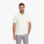 Man wearing a white polo shirt and gray pants on a white background