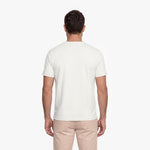 Man wearing a plain white t-shirt and beige pants on a white background