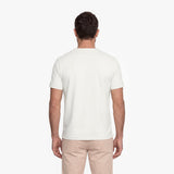 Man wearing a plain white t-shirt and beige pants on a white background