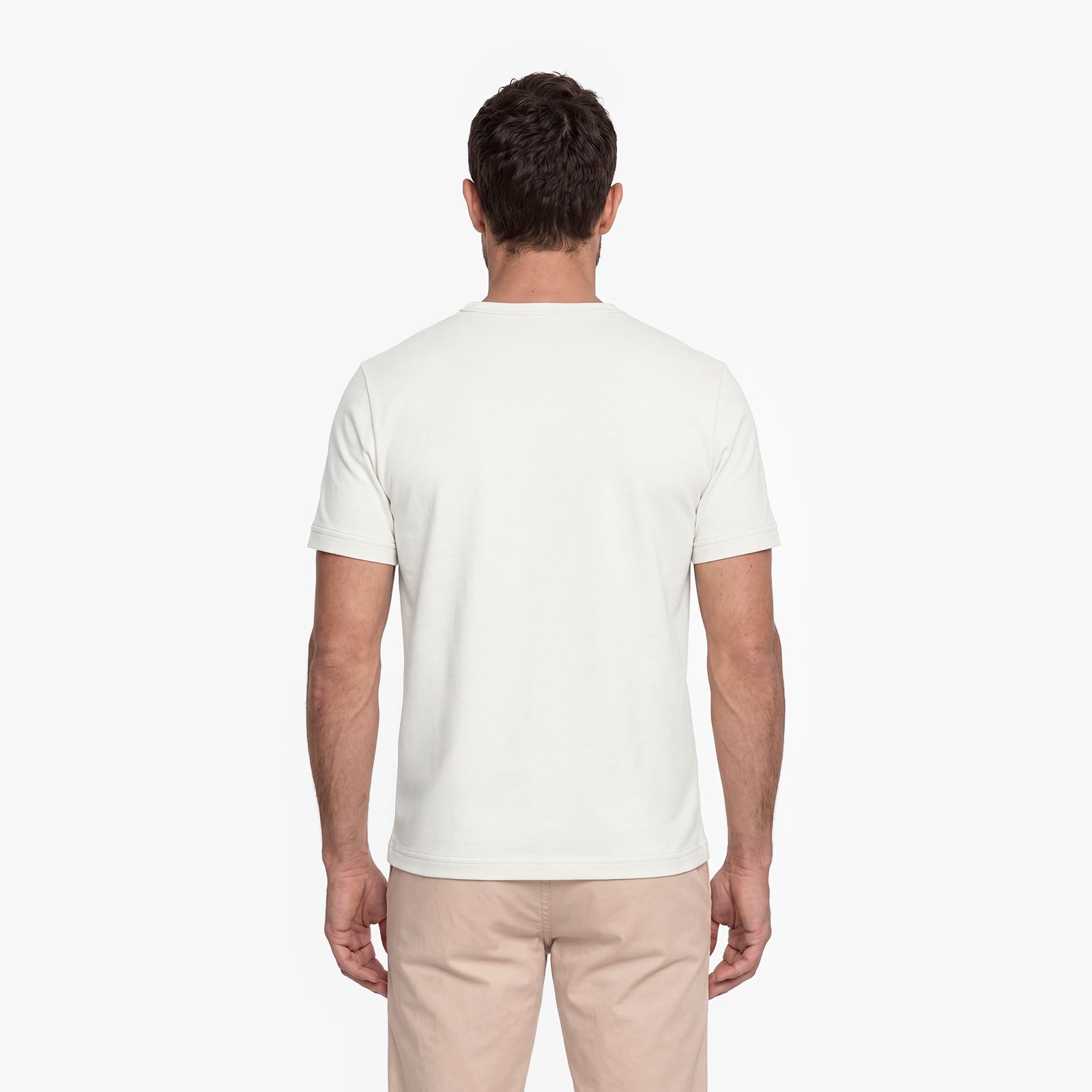 Man wearing a plain white t-shirt and beige pants on a white background