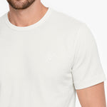 White t-shirt worn by a person on a white background