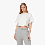A woman modeling a white cropped short-sleeve t-shirt and light gray sweatpants