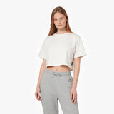 A woman modeling a white cropped short-sleeve t-shirt and light gray sweatpants