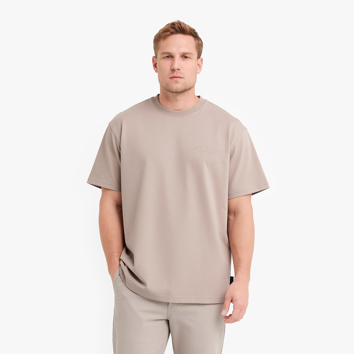 A man wearing a light taupe crewneck t-shirt and matching pants