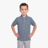 A young boy modeling a slate blue polo shirt with a small embroidered dog logo on the chest