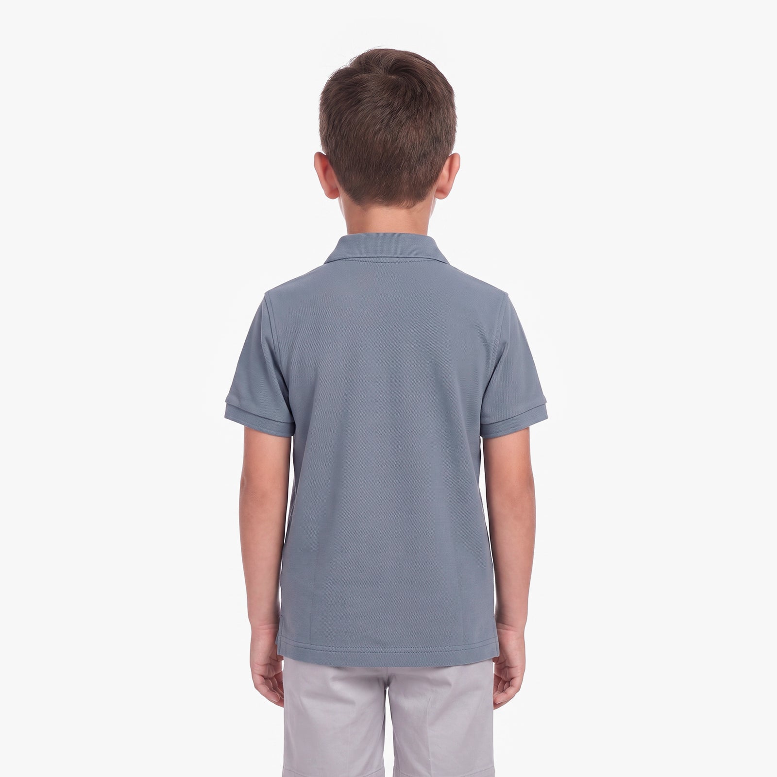 Back view of a boy wearing a slate blue polo shirt