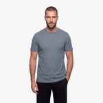 Man wearing a gray t-shirt with a small logo on a white background