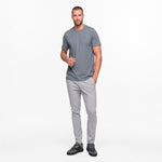 Man wearing a gray t-shirt and pants on a white background