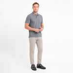 A man modeling a short-sleeve gray polo shirt with beige trousers, standing against a white background.