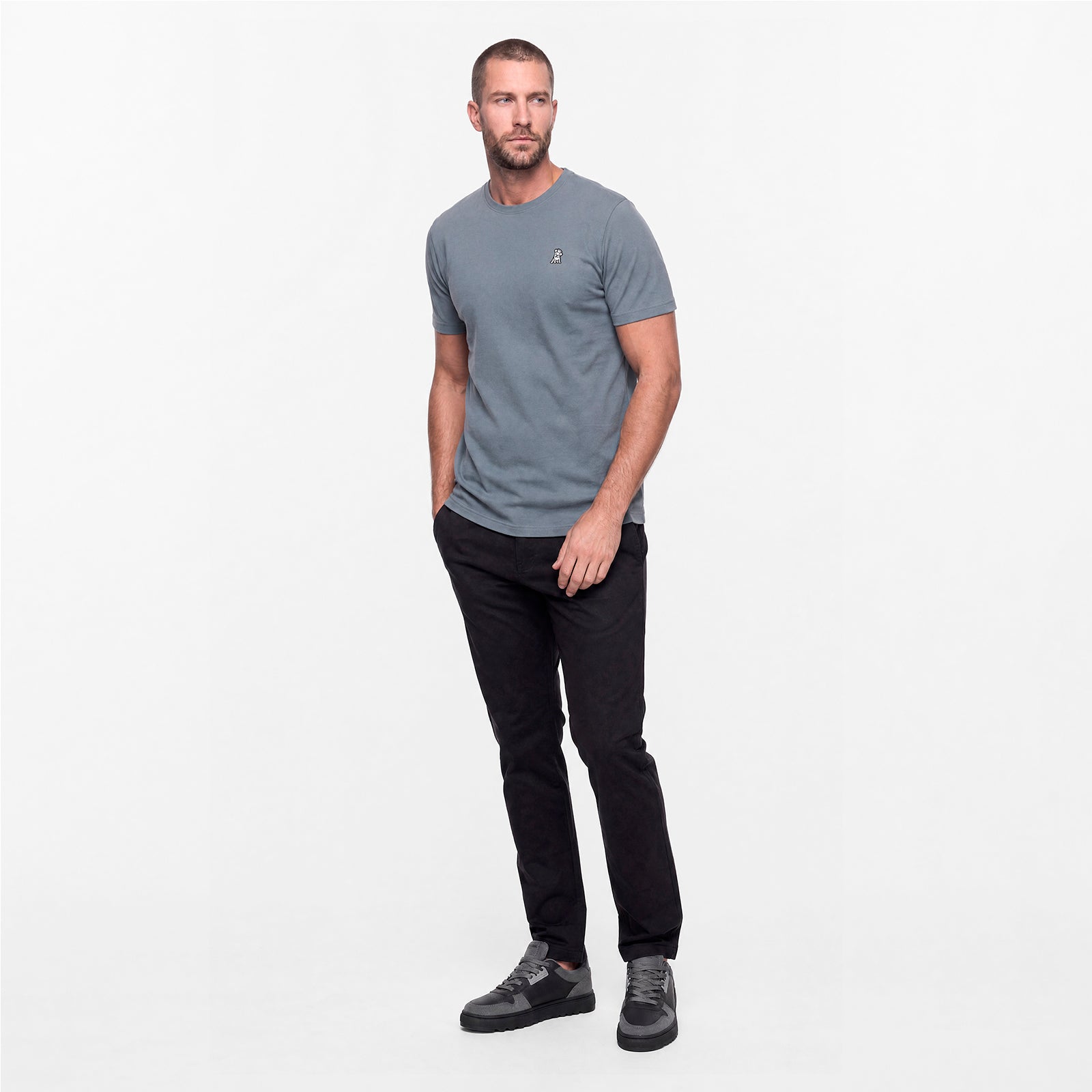 Man wearing a gray t-shirt and black pants on a white background