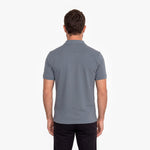 Back view of a man wearing a gray polo