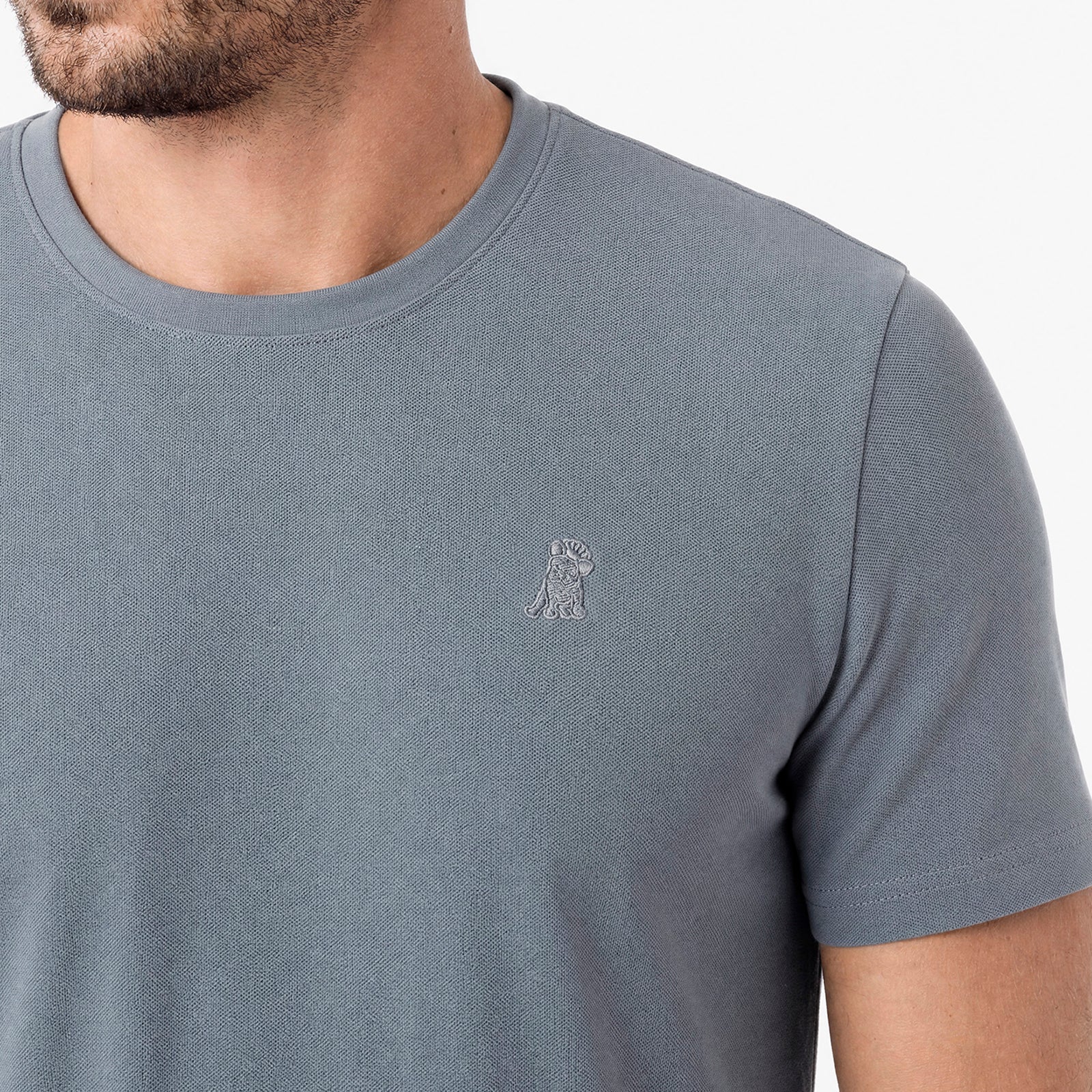 Gray t-shirt with a small logo on a white background