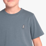 A close-up of a child wearing a slate blue-gray crewneck t-shirt with a small white and black cartoon dog on the left chest