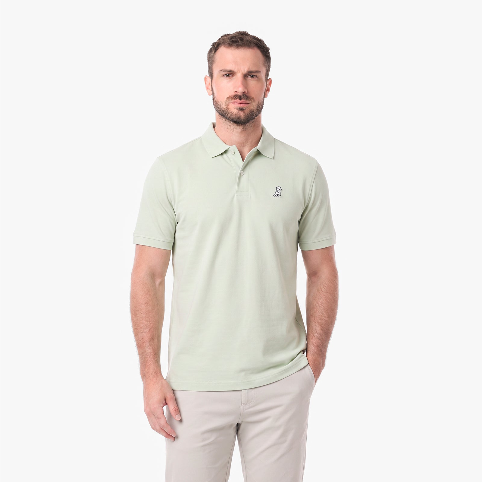 A man wearing a light green polo shirt with a small embroidered logo on the left chest