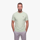 Man wearing a light green t-shirt with a white logo on a white background