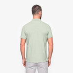 Man wearing a light green polo shirt on a white background