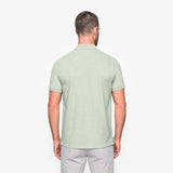 Man wearing a light green polo shirt on a white background