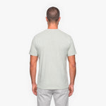 Man wearing a light gray t-shirt and pants on a white background