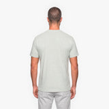 Man wearing a light gray t-shirt and pants on a white background