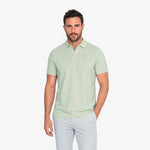 Man wearing a light green polo on a white background