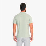 Man wearing a light green polo shirt on a white background
