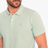 Close-up of a light green polo with a light green embroidered logo