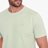 Light green t-shirt with a small logo on a white background