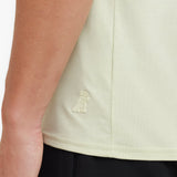 Close-up of a light green sleeveless top with a logo on a person wearing it.