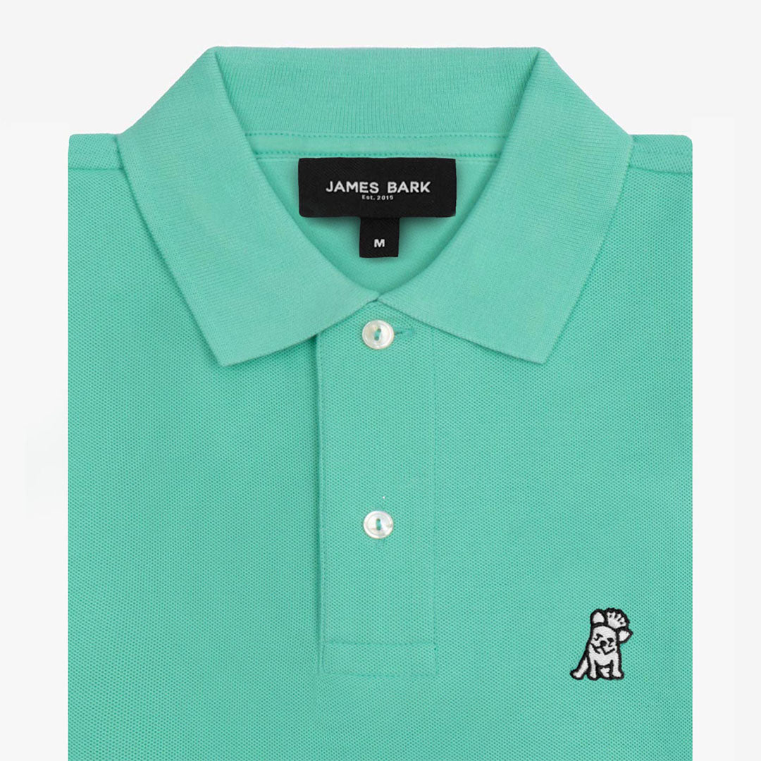 Close-up of the collar and logo of the bright green polo shirt, showing button details.