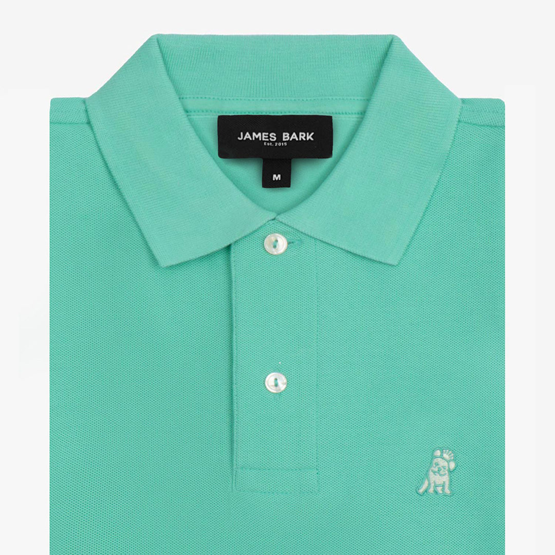 Close-up of the collar and tag of the bright green polo shirt, highlighting the button details.