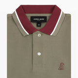 Close-up of the collar and buttons of the olive polo shirt: A detailed view of the maroon collar with white piping, showing the button placket and the small embroidered dog logo on the chest.