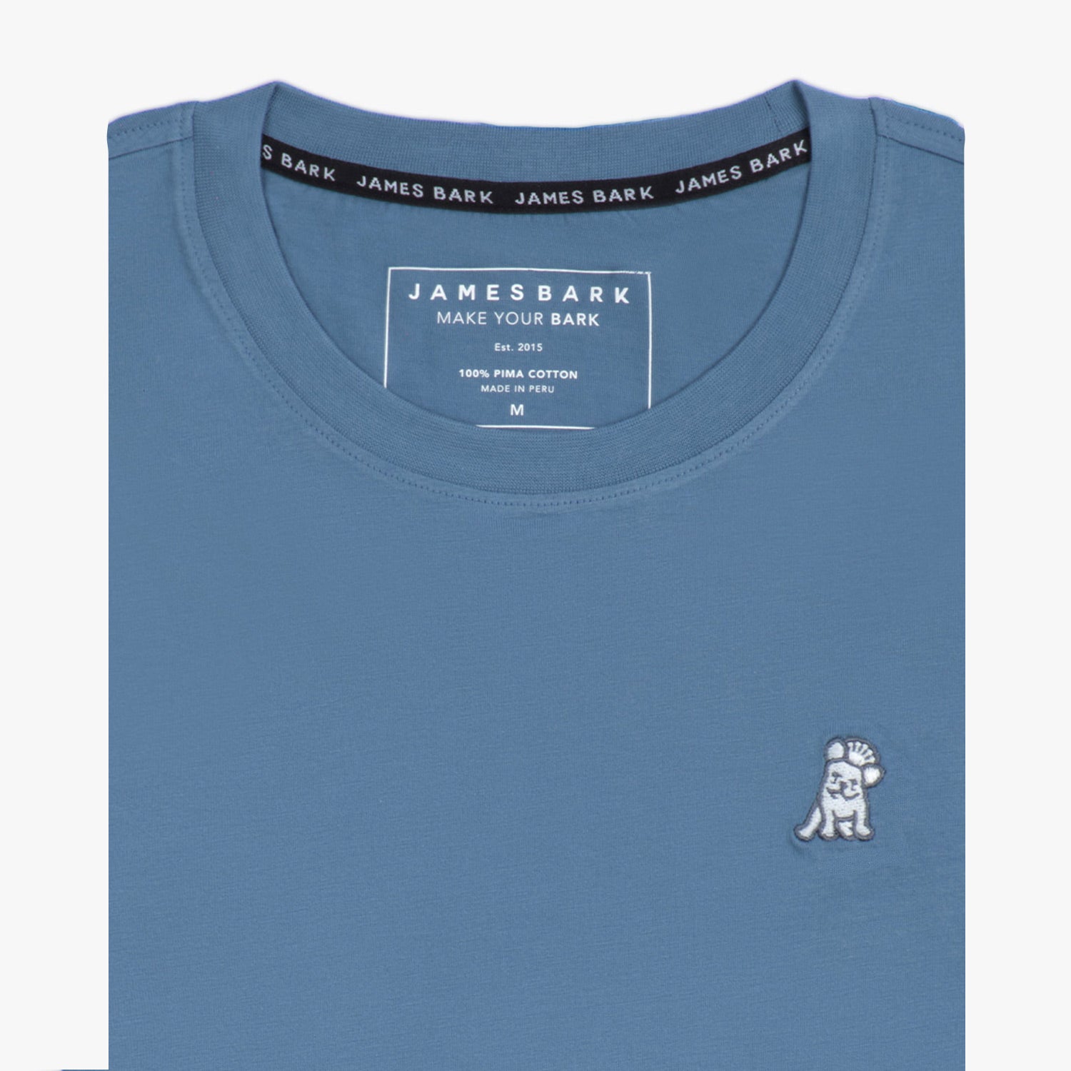 Close-up of the blue t-shirt showing the crew neckline and a small embroidered animal logo on the left chest.