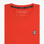 The orange t-shirt laid flat, showing the front of the shirt with the small embroidered animal logo on the left chest.