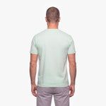 Man wearing a light green t-shirt on a white background