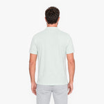 Man wearing a light green polo shirt on a white background